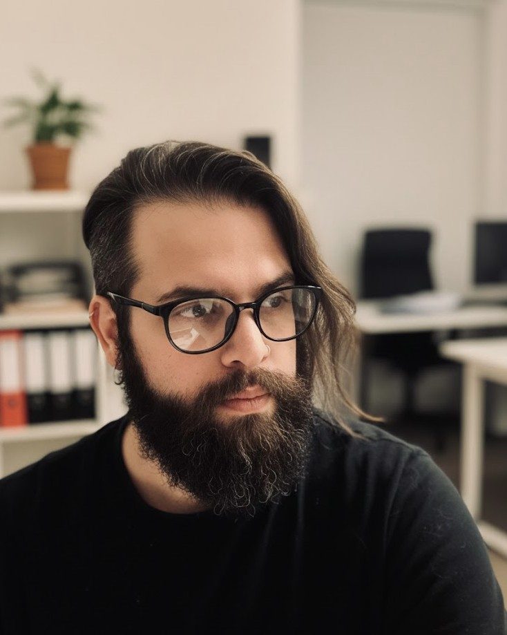 Portrait of Rick Rocharca, wearing glasses and looking to the side